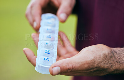 Buy stock photo Pill box, weekly medicine and hand closeup of a sport athlete on a soccer field with tablet and drugs for health. Supplements, plastic container and outdoor with a man holding wellness and medication