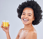 Woman, portrait and glass of orange juice in studio for vitamin c benefits on gray background. Face, happy african model and drink citrus fruit smoothie for healthy nutrition, diet and natural beauty
