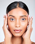 Studio portrait of Indian woman with hands for skincare, beauty and cosmetics on white background. Dermatology, spa and serious face of isolated person for wellness, satisfaction and facial treatment
