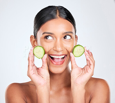 Face, excited and woman with cucumber, beauty and facial with natural skincare isolated on white background. Wellness, vegetable and vegan cosmetics product with glow, shine and green in studio