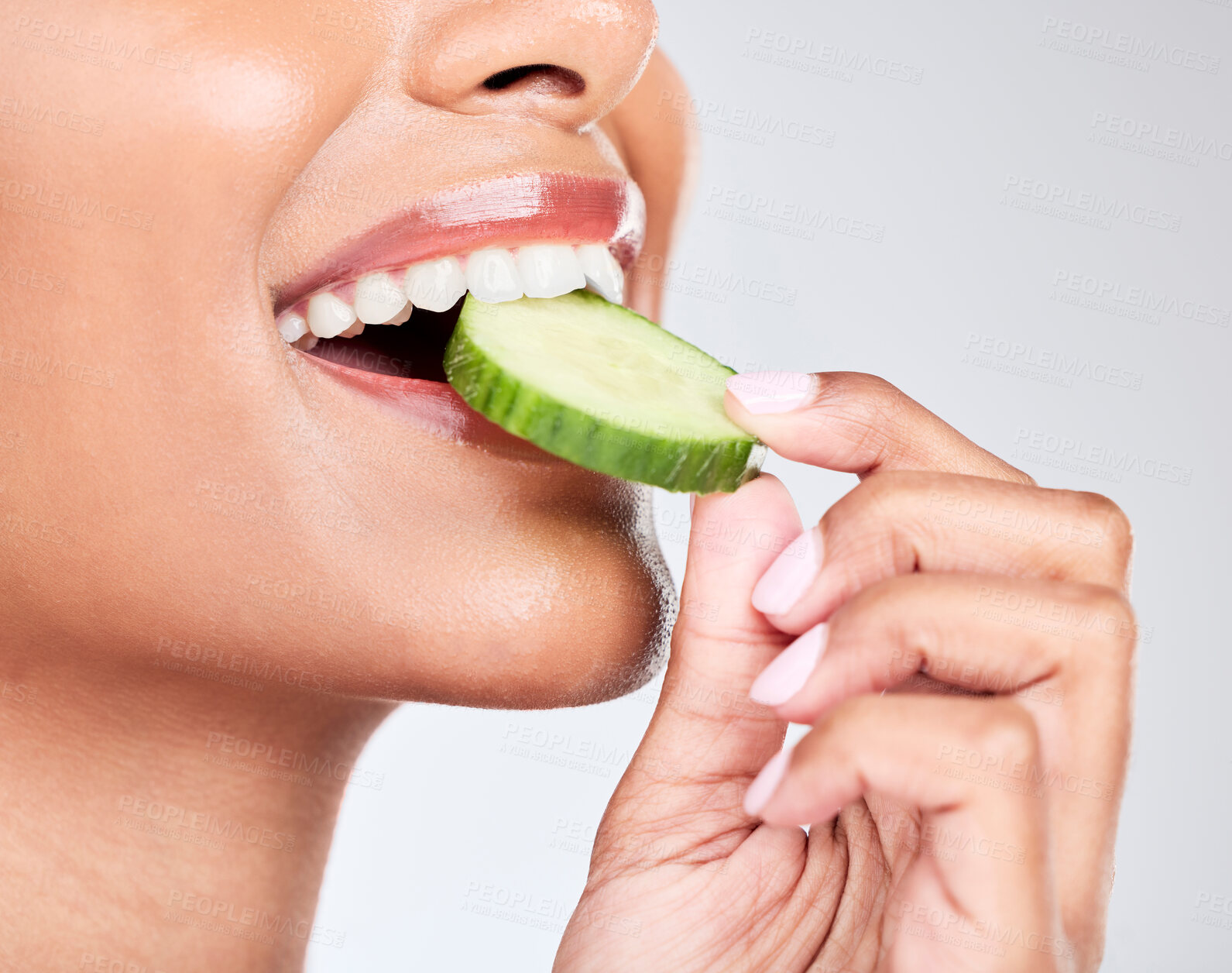 Buy stock photo Woman, mouth and eating cucumber in studio closeup for health, diet and detox by white background. Girl, model and nutrition with fruit, vegetable and vegan food for beauty, skincare and wellness