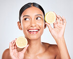 Face, smile and woman with lemon, beauty and facial with natural skincare isolated on white background. Wellness, fruit and vegan cosmetic product with glow, shine and vitamin c with citrus in studio