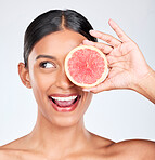 Grapefruit, happy woman and face with beauty, healthy and natural skincare with citrus fruit on white background. Wellness, vitamin c and smile for cosmetics product, eco friendly and vegan in studio