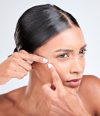 Buy stock photo Woman, face and squeeze acne in studio of breakout, dermatology or worry of scar on white background. Indian model check facial beauty to pop pimple, scratch blackhead or stress of sensitive skincare