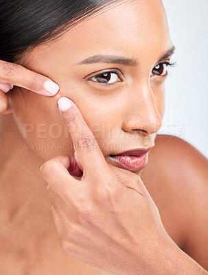 Buy stock photo Face, woman and squeeze acne in studio of glowing spot, breakout or check dermatology on white background. Indian model, facial beauty and pop pimple, scratch blackhead and scar of sensitive skincare