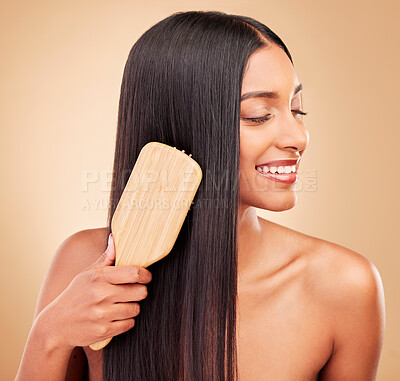 Buy stock photo Hair care, brush and young woman in a studio with salon keratin treatment for wellness and self care. Grooming, cosmetic and Indian female model with tool for hairstyle isolated by a brown background