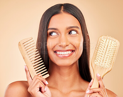 Buy stock photo Brush, comb and young woman in a studio for salon, keratin or cosmetic treatment for wellness. Health, happy and Indian female model with natural bamboo hair tools isolated by a brown background.