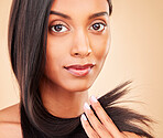 Hair care, beauty and portrait of woman in a studio with split ends for salon keratin treatment. Makeup, cosmetic and headshot of Indian female model with hairstyle isolated by a brown background.