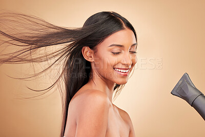 Buy stock photo Beauty, hairdryer and young woman in a studio with salon keratin treatment for wellness. Hair care, cosmetic and Indian female model with cosmetology tool for hairstyle isolated by a brown background
