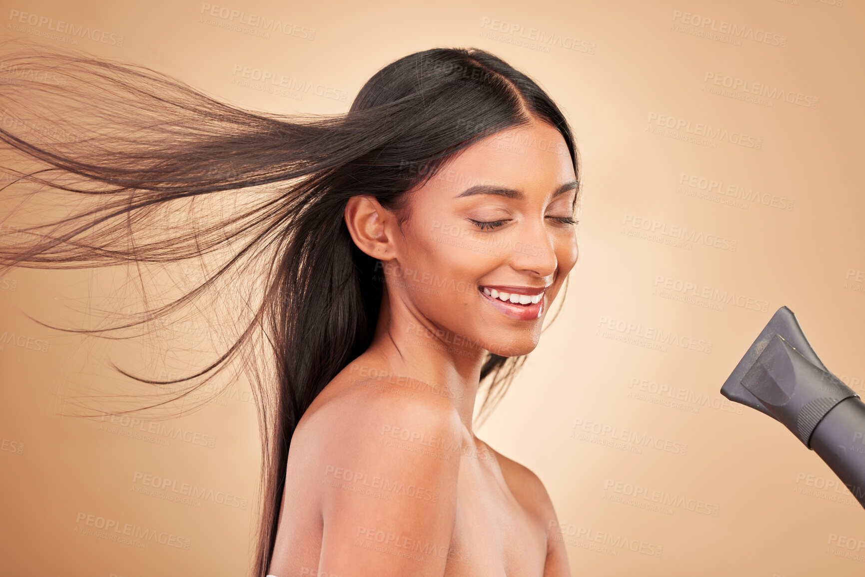 Buy stock photo Beauty, hairdryer and young woman in a studio with salon keratin treatment for wellness. Hair care, cosmetic and Indian female model with cosmetology tool for hairstyle isolated by a brown background