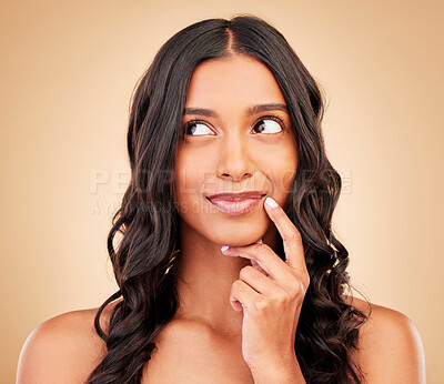 Buy stock photo Makeup, thinking and young woman in a studio for beauty, cosmetic and glow face routine. Self care, idea and Indian female model with natural facial cosmetology treatment isolated by brown background