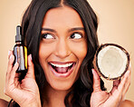 Happy woman, hair and beauty, coconut oil product with natural treatment and cosmetic care on studio background. Haircare, eco friendly and vegan with fruit, serum and shampoo with bottle and shine