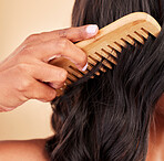 Comb, hair care and closeup of woman in studio with clean salon treatment hairstyle for wellness. Beauty, cosmetic and zoom of female model with tool for haircut maintenance by a brown background.