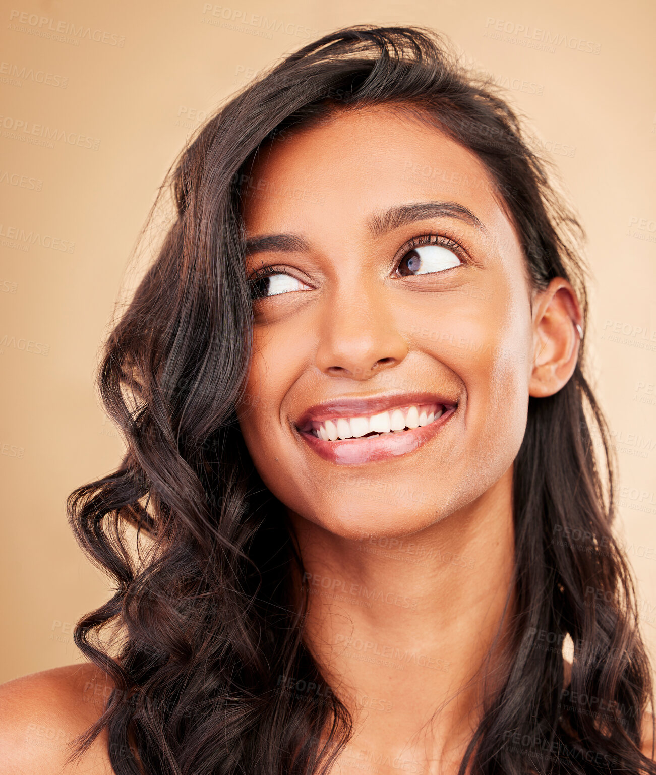 Buy stock photo Curly hair, beauty and smile of woman in studio isolated on a brown background. Hairstyle care, natural cosmetics and Indian model thinking in salon treatment for health, hairdresser and balayage