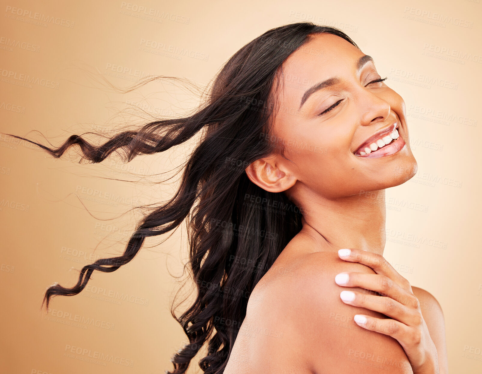 Buy stock photo Curly hair, smile and woman in wind at studio isolated on a brown background. Hairstyle breeze, natural cosmetics and happy Indian model in salon treatment for beauty care, hairdresser and balayage