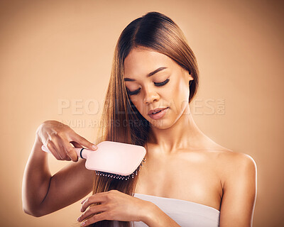 Buy stock photo Hair, brush and a woman in studio for beauty, cosmetics and shine. Aesthetic model person on brown background for wellness, healthy growth and hairdresser or salon results with self care benefits