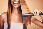 Hand, hair straightener and woman in studio for beauty, cosmetics or appliance. Happy person on brown background for heat treatment, healthy results and hairdresser or salon flat iron on texture