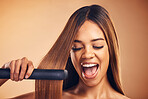 Excited, hair straightener and beauty of a woman in studio for cosmetics or mockup. Aesthetic model on brown background for wow heat treatment, healthy results and hairdresser or salon flat iron
