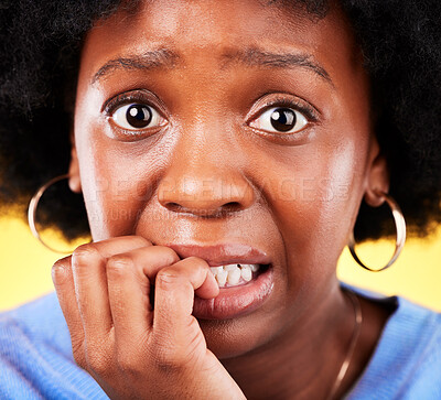 Buy stock photo Anxiety, biting nails and a woman scared in studio with fear, mental health or nervous behaviour. Face portrait of African person on yellow background worried, stress or panic for phobia or horror