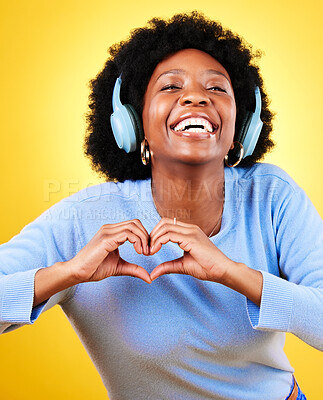Buy stock photo Portrait, heart hands and headphones of woman in studio for sign, kindness or thank you on yellow background. Happy african model, finger shape or icon of hope, love or emoji while listening to music