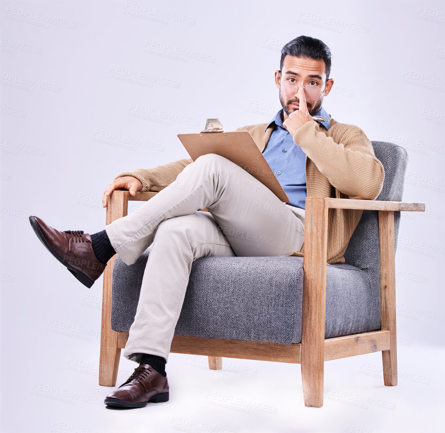 Buy stock photo Portrait, concern and a man psychologist in a chair on a white background in studio to listen for diagnosis. Psychology, mental health and serious with a person counseling during a therapy session