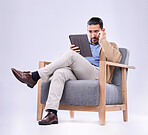 Tablet, concern and a man psychologist in a chair on a white background in studio to listen for diagnosis. Psychology, mental health and reading information with a person counseling during therapy