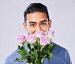 Portrait, gift and man with flowers, celebration and romance on a white studio background. Face, person and model with bouquet, plants and present with love, romantic and guy with happiness and care