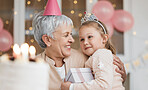 Home, hug and grandma with girl, birthday and gift with celebration, happiness and bonding. Decorations, granny or kid with a present, party or embrace with child, love or excited with care and smile