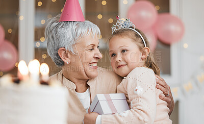 Buy stock photo Home, hug and grandma with girl, birthday and gift with celebration, happiness and bonding. Decorations, granny or kid with a present, party or embrace with child, love or excited with care and smile