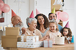 Happy birthday, gift and big family celebrate with cake in a home party, event and candles in a house together. Mother, father and grandparents excited for surprise gathering with children or kids