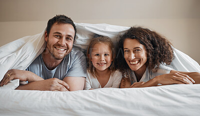 Buy stock photo Smile, love and portrait of family in bed for bonding, relaxing and resting together with blanket. Happy, excited and young girl child laying with her mother and father in the bedroom of modern home.