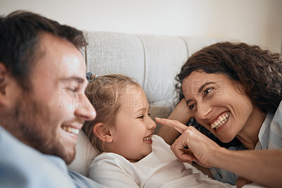 Buy stock photo Love, happy and a family in bed for bonding, playing and together in a house for comfort. Smile, care and a young and playful mother, father and girl kid in the bedroom for touch or laughing