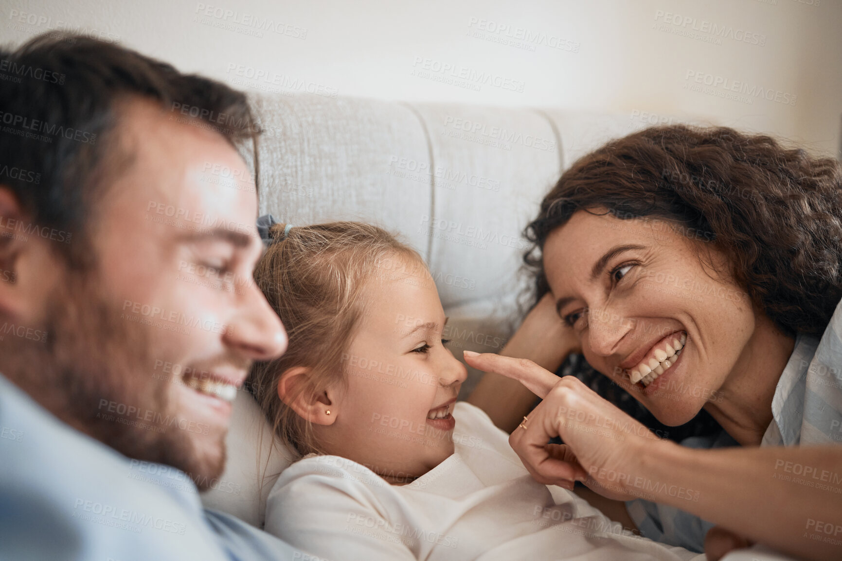 Buy stock photo Love, happy and a family in bed for bonding, playing and together in a house for comfort. Smile, care and a young and playful mother, father and girl kid in the bedroom for touch or laughing