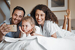 Selfie, happy and family on a bed together for bonding on a weekend morning at modern home. Smile, goofy and girl child taking a picture with her mother and father in the bedroom for memory at house.