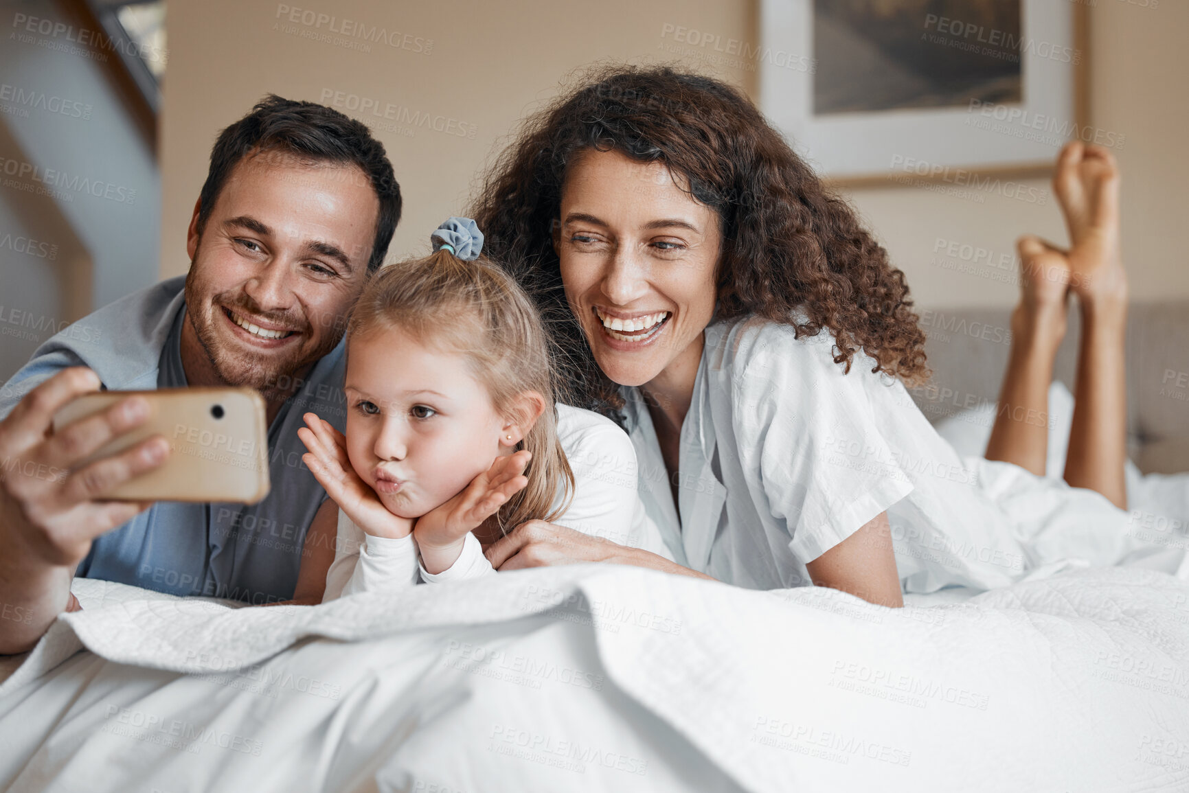 Buy stock photo Selfie, happy and family on a bed together for bonding on a weekend morning at modern home. Smile, goofy and girl child taking a picture with her mother and father in the bedroom for memory at house.