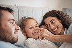 Family, bed and parents playing with their daughter in the morning to relax after waking up together. Kids, love or smile with a man, woman and cute nose of a child joking in the bedroom closeup