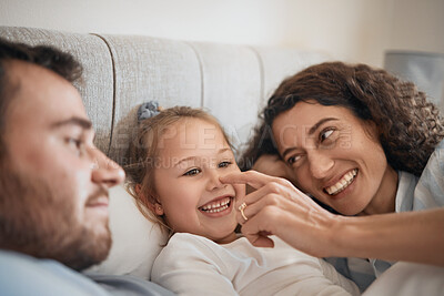 Buy stock photo Family, bed and parents playing with their daughter in the morning to relax after waking up together. Kids, love or smile with a man, woman and cute nose of a child joking in the bedroom closeup