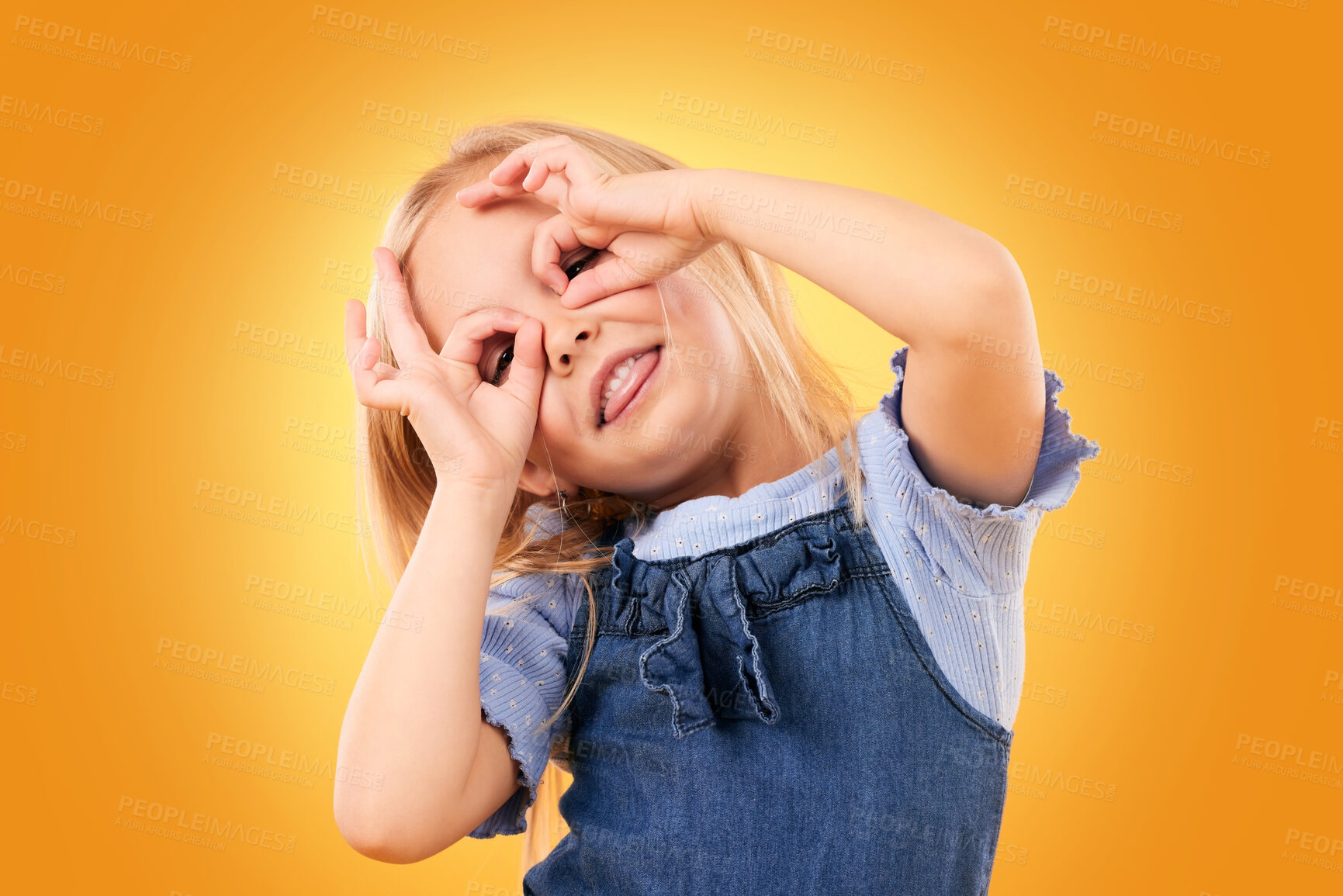 Buy stock photo Kids, fun and hand glasses by girl in studio playing, free and funny gesture against orange background space. Finger, frame and child with silly expression, mood or personality, playful or games