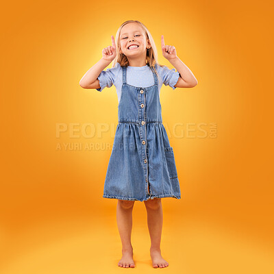 Buy stock photo Happy, child portrait and pointing up in studio for advertising, announcement or promotion. Excited barefoot girl kid on orange background for hand gesture, sale or sign for attention or mockup space