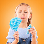 Portrait, children and sad girl with a broken lollipop on an orange background in studio looking upset. Kids, candy and unhappy with a female child holding a cracked piece of a sugar snack in regret