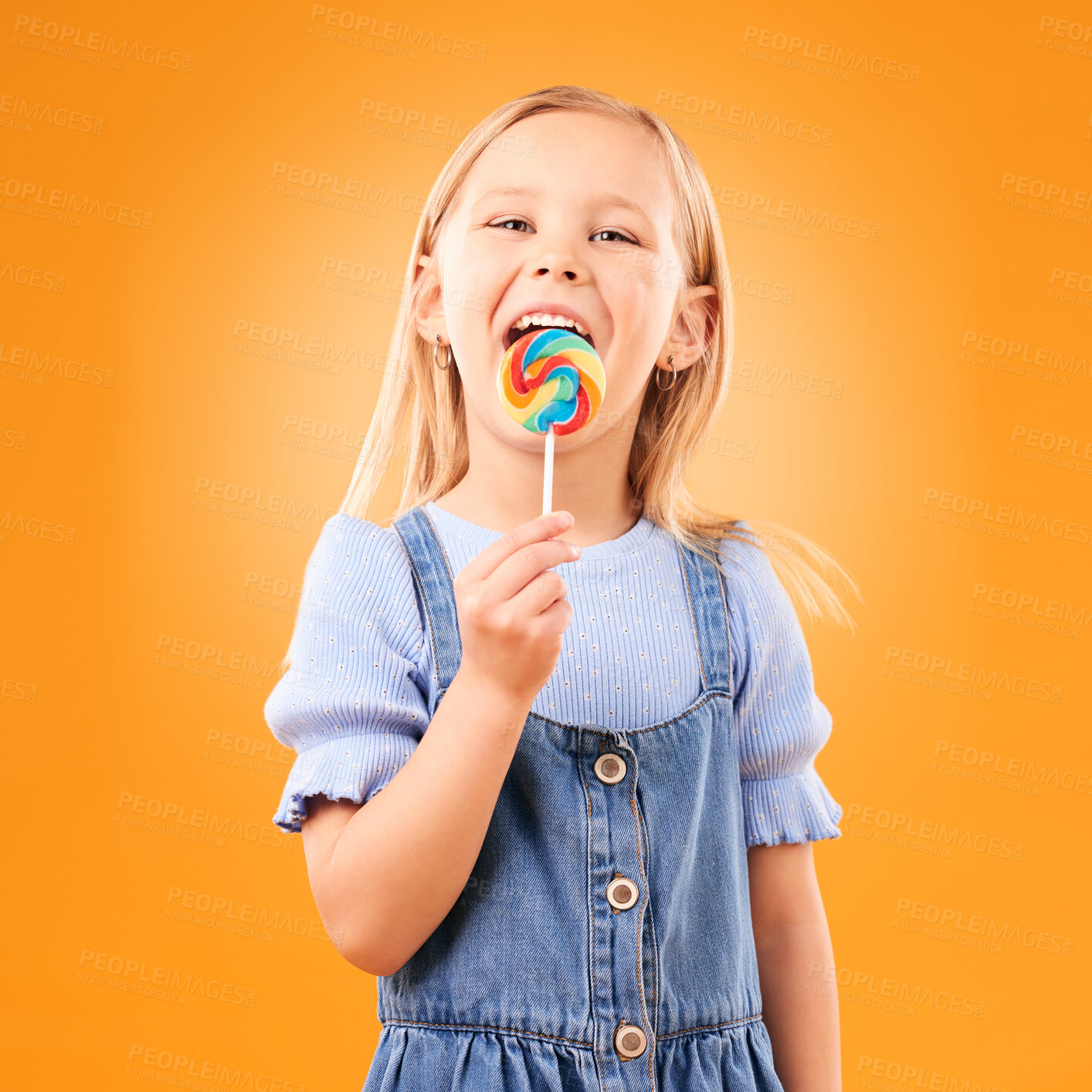 Buy stock photo Lollipop, girl child and portrait of candy in hand, eating and studio for sweets, birthday party or carnival. Sugar, kid and lick spiral snack for dessert, hunger or meal on orange background