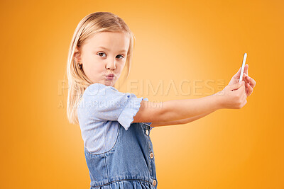 Buy stock photo Phone, selfie or portrait of child in studio with confidence or mockup space in photograph memory. Kid, orange background or face of girl taking picture online on a social media app on internet