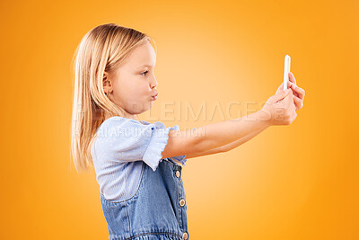 Buy stock photo Phone, selfie or profile of kid in studio with confidence or mockup space in photograph memory. Pout, orange background or young girl child taking picture online on a social media app on internet