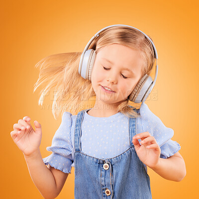 Buy stock photo Headphones, dancing or child streaming music to relax with freedom in studio on orange background. Hair, moving or girl dancer listening to a radio song, sound or gospel on an online subscription