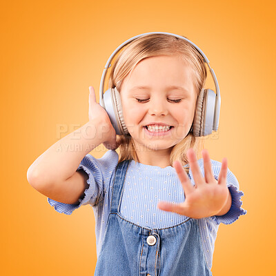 Buy stock photo Headphones, dancing or child streaming music to relax with freedom in studio on orange background. Smile, excited and happy girl listening to a radio song, sound or audio on an online subscription