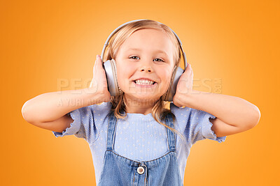 Buy stock photo Headphones, portrait or child streaming music to relax with freedom in studio on orange background. Face, smile or happy girl listening to a fun radio song, sound or audio on an online subscription