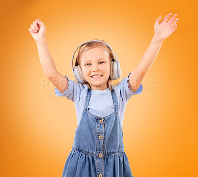 Buy stock photo Portrait, child and dance with headphones in studio for freedom, music and excited party on orange background. Happy girl with energy listening to audio, streaming sound and celebrate song on radio 