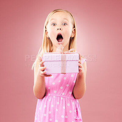 Present, gift and wow portrait of a child in studio for birthday, holiday or happy celebration. Excited girl on a pink background with ribbon, mouth open and amazing surprise giveaway prize in box