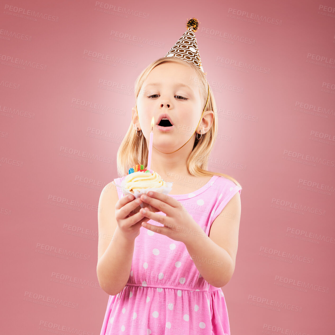 Buy stock photo Cupcake, birthday and child blow candle for holiday party, happy celebration and a wish. Young girl kid on a pink background for surprise, cake or celebrate achievement with a dessert and fun