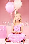 Balloons, birthday and portrait of girl in studio for party, celebration and special day. Happy, excited and young child sitting with presents, gift box and decoration for event on pink background